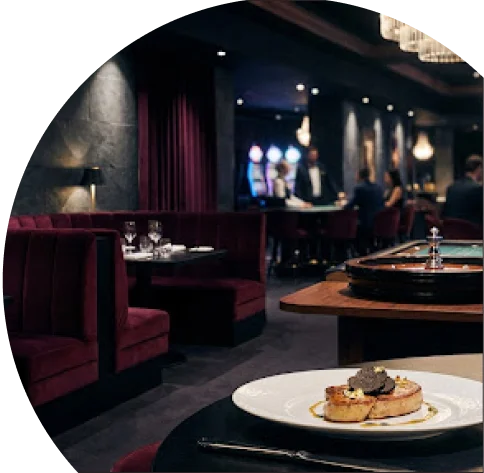 Un plat gastronomique de foie gras poêlé garni de tranches de truffe noire sur une table dans l'ambiance feutrée d'un casino ou salon élégant