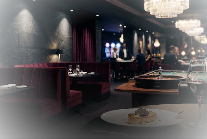 Intérieur luxueux d'un restaurant de casino avec des banquettes en velours rouge, une roulette, des lustres élégants et un plat gastronomique au premier plan